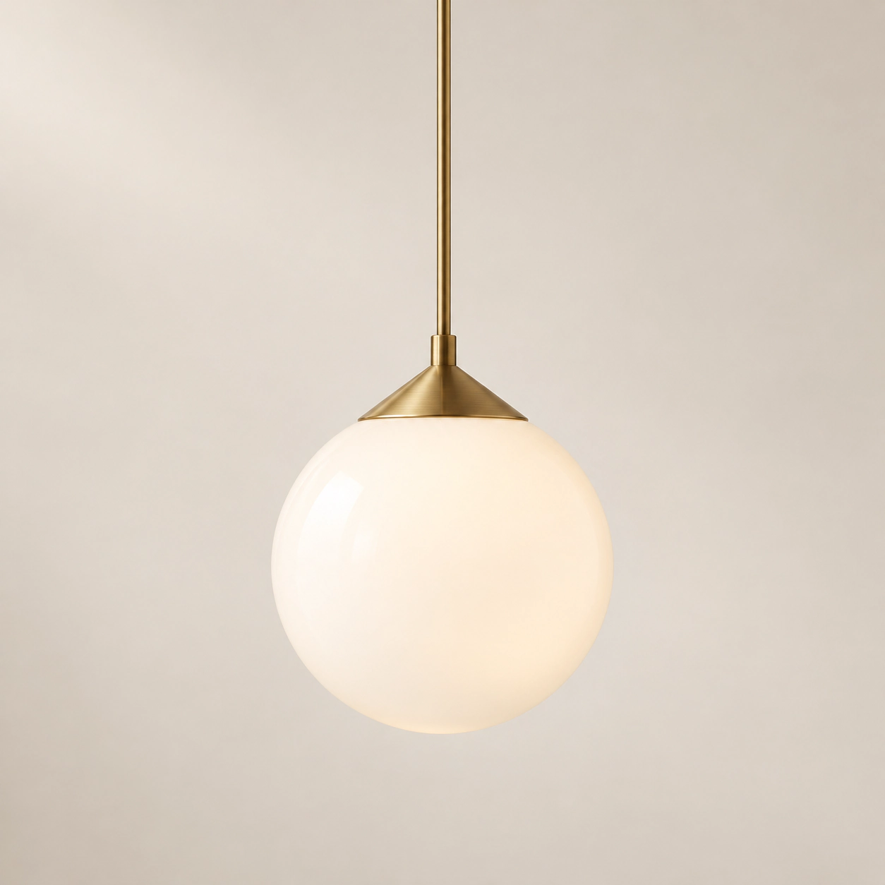 An opal glass pendant with brushed brass detailing